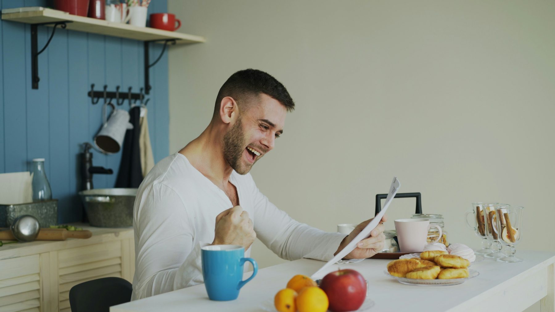 A freelancer celebrating at his kitchen table